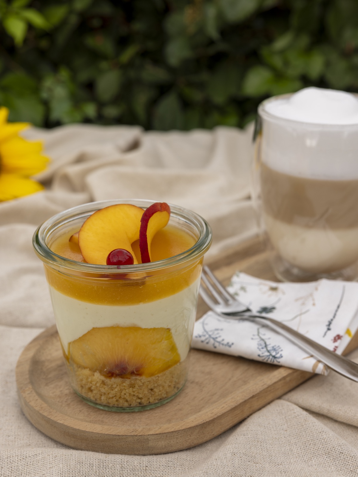 Ein Dessert, das in einem durchsichtigen Glasgefäß mit Deckel serviert wird und auf einem Tisch platziert ist.