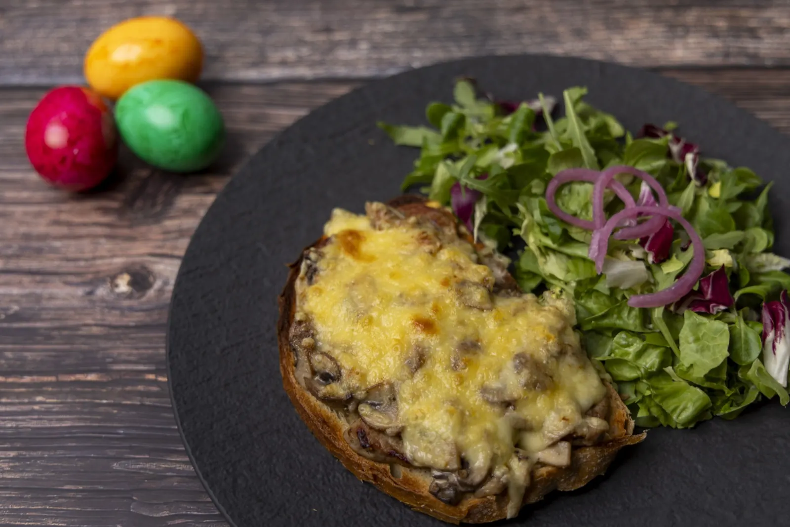 Überbackener Toast mit Pilzen und Käse, dazu Salat