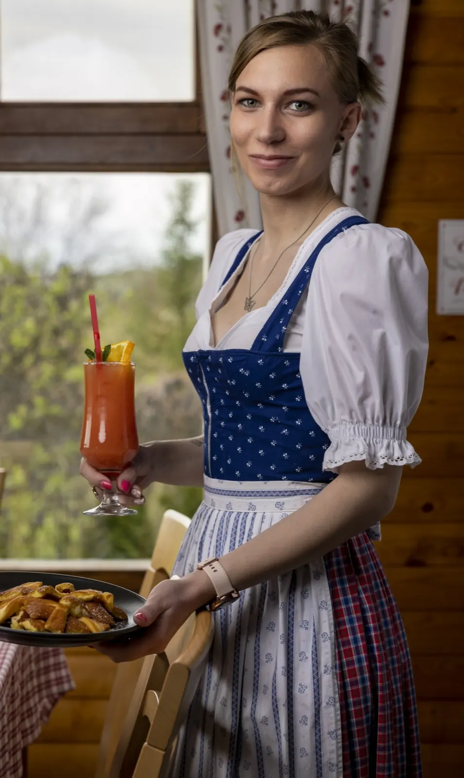 Frau im Dirndl mit einem Schichtcocktail