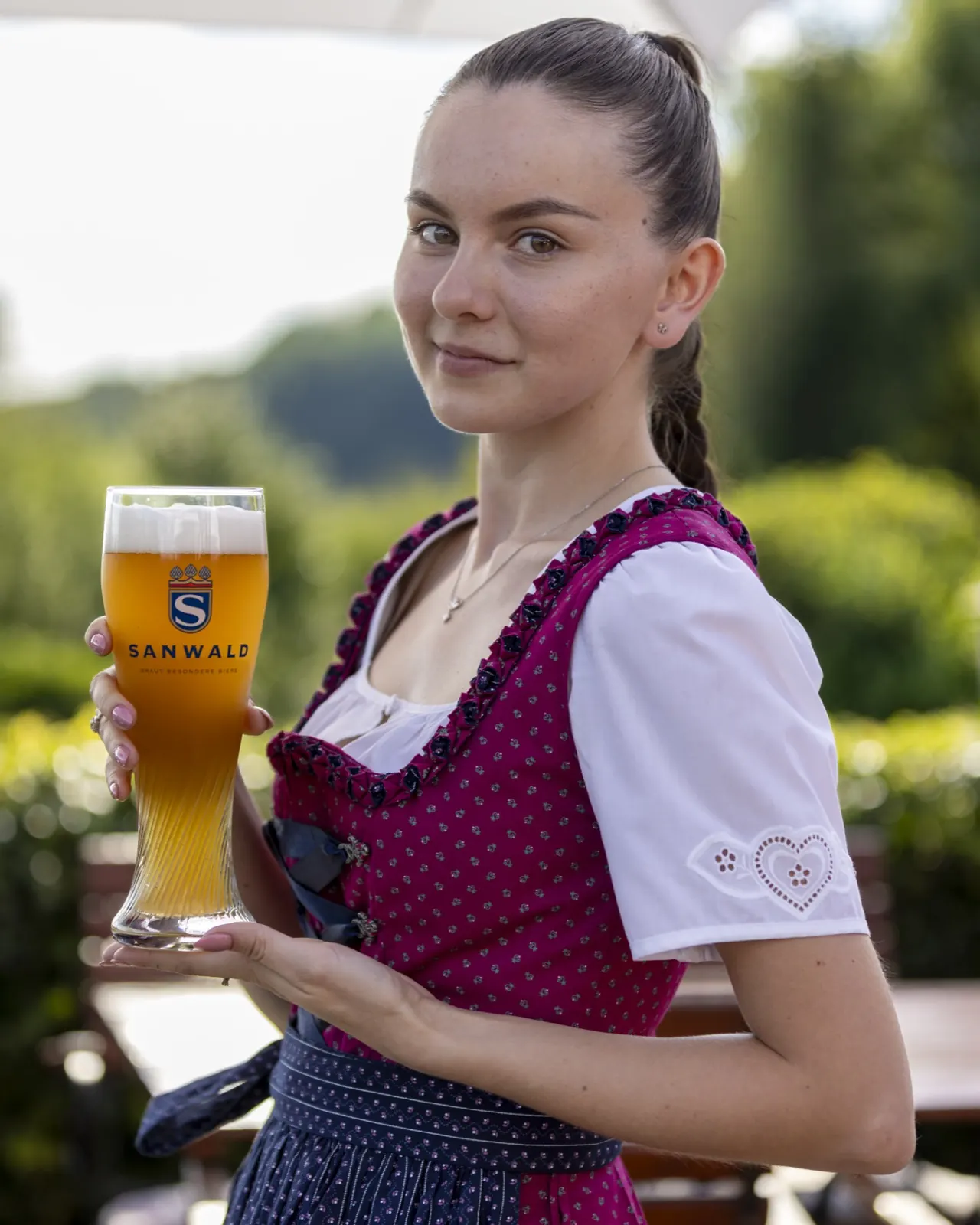 Frisch gezapftes Weizenbier, serviert im Dirndl auf der Terrasse